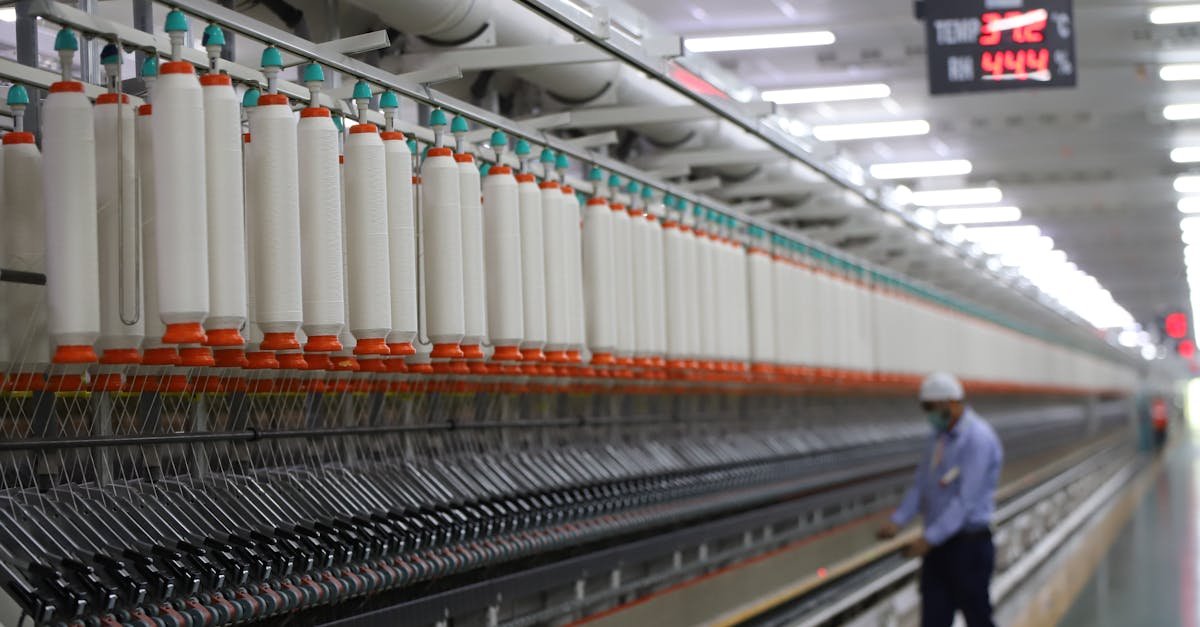 Textile A worker manages textile machinery in a modern industrial plant in India.
