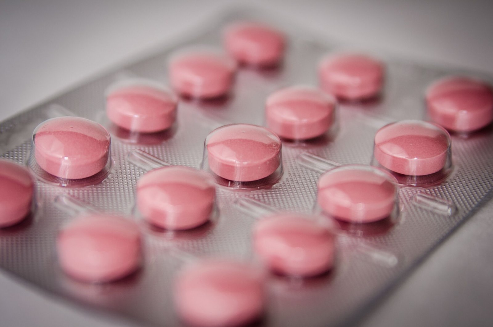 Other Industries Pink tablets in a blister pack, emphasizing healthcare and medication concepts.