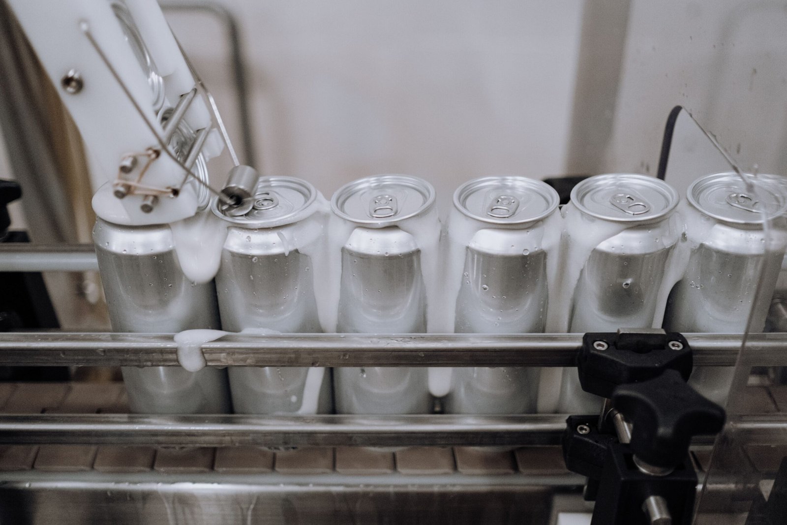 FOod Close-up of aluminum cans on an assembly line in a modern brewery showing automation and machinery at work.
